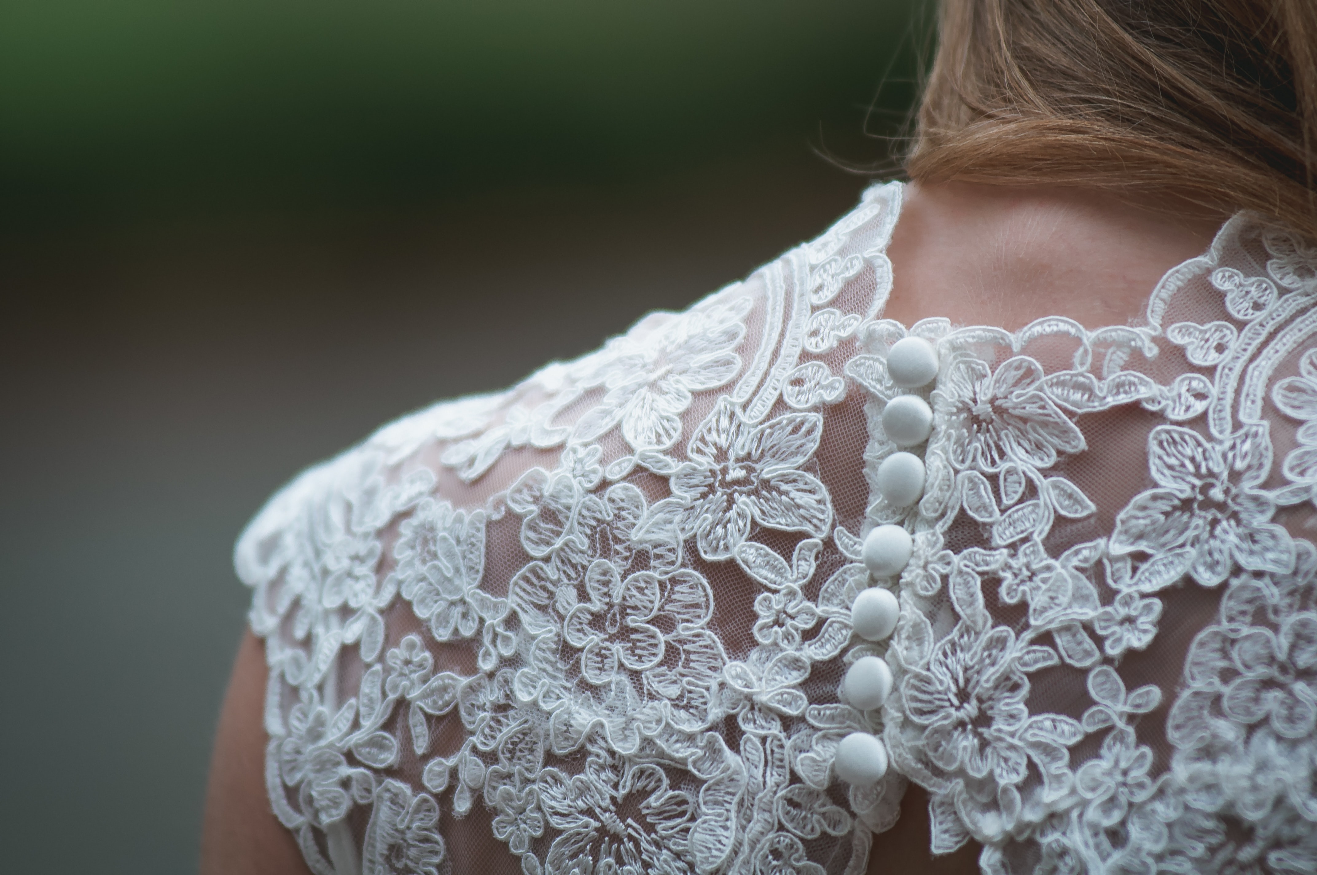 Image shows the details on the back of a Brides dress showing lace and buttons